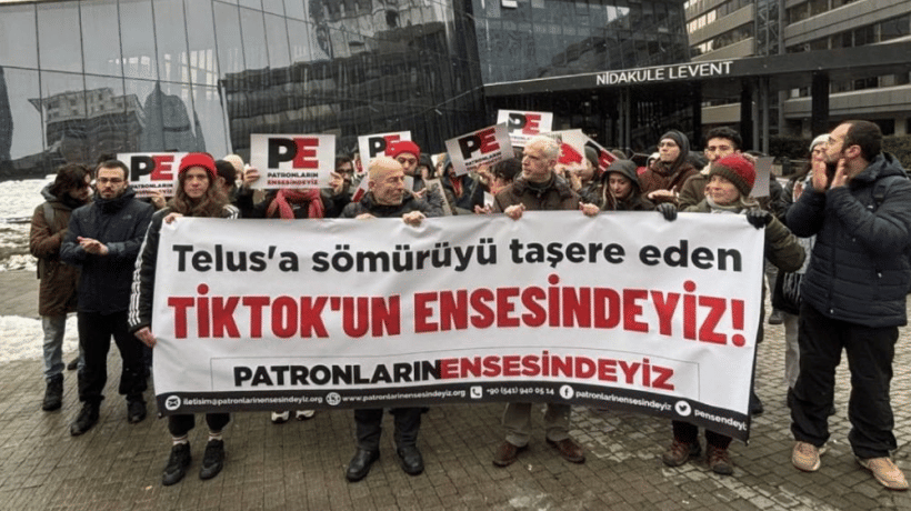 A group of protesters gather in front of TikTok’s office in Türkiye, holding a large banner accusing outsourcing firm Telus of violating workers' rights. The demonstration highlights issues such as union-busting, wage underpayment, and the company's failure to address workplace harassment cases.